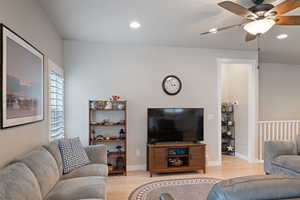 Living area with a ceiling fan, light wood finished floors, recessed lighting, and baseboards