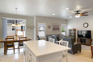 Kitchen with plenty of natural light, white cabinetry, a chandelier, light wood finished floors, and recessed lighting