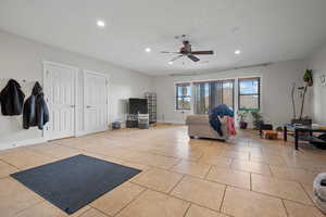 Living area with light tile patterned floors, a ceiling fan, and recessed lighting