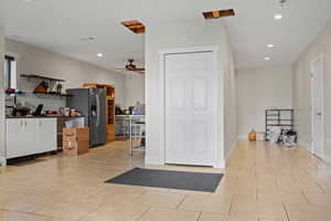Interior space with a ceiling fan, light tile patterned floors, and recessed lighting
