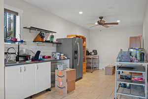 Kitchen featuring a sink, open shelves, dark countertops, white cabinets, and ceiling fan