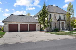 French country style house featuring driveway, stucco siding, a garage, and stone siding