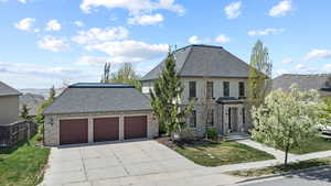 View of front of property featuring fence, stone siding, and a front yard