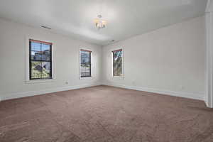 Spare room featuring baseboards, carpet flooring, and visible vents