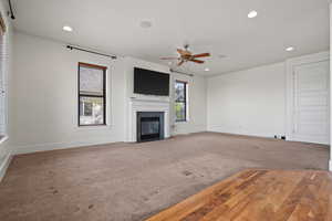 Unfurnished living room with recessed lighting, baseboards, ceiling fan, and carpet floors