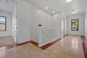 Hallway featuring baseboards, a wealth of natural light, tile patterned flooring, and recessed lighting