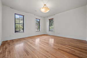 Spare room with light wood finished floors, baseboards, and a healthy amount of sunlight