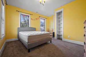 Carpeted bedroom with baseboards and visible vents