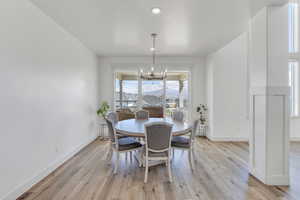 Dining space featuring light wood finished floors, an inviting chandelier, and baseboards