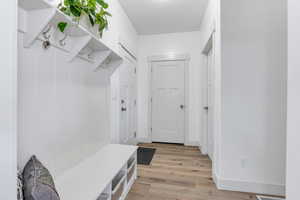 Mudroom with light wood-style flooring and baseboards
