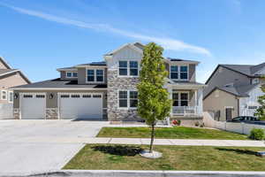 Craftsman inspired home featuring stone siding, solar panels, and covered porch