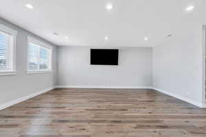 Unfurnished room with wood finished floors, baseboards, and recessed lighting