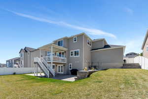 Back of property with a lawn, a patio area, stairs, stucco siding, and a fenced backyard