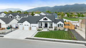 Modern farmhouse with stone siding, a residential view, concrete driveway, and an attached garage