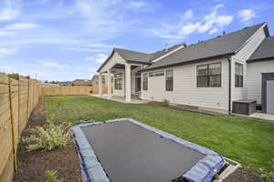 Back of property featuring a yard, a shingled roof, a patio area, and a fenced backyard