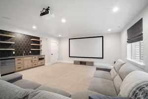 Cinema featuring baseboards, recessed lighting, light colored carpet, and indoor wet bar