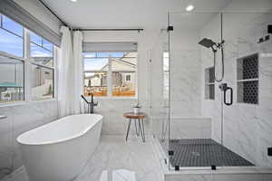 Full bathroom with a soaking tub, marble finish floor, a stall shower, and recessed lighting