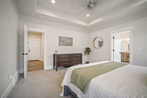 Carpeted bedroom featuring visible vents, baseboards, a raised ceiling, and recessed lighting