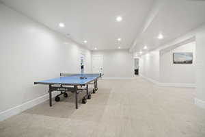 Recreation room featuring light colored carpet, baseboards, and recessed lighting