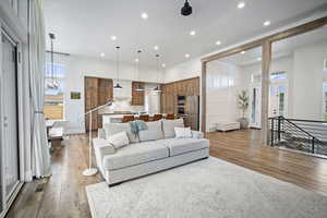 Living area with recessed lighting, plenty of natural light, and wood finished floors