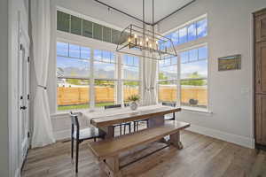 Dining space featuring baseboards, a chandelier, visible vents, and wood finished floors