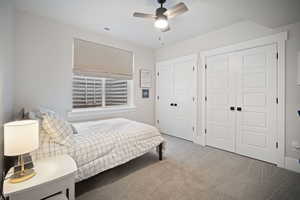 Bedroom with carpet, a ceiling fan, multiple closets, and visible vents