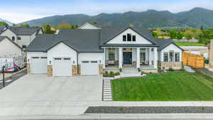 View of front of home featuring board and batten siding, a porch, a shingled roof, stone siding, and an attached garage