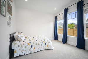 Carpeted bedroom with vaulted ceiling, baseboards, and recessed lighting
