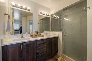 Ensuite bathroom featuring a stall shower, visible vents, a sink, and double vanity