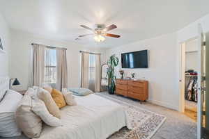 Bedroom featuring visible vents, baseboards, ceiling fan, and light carpet