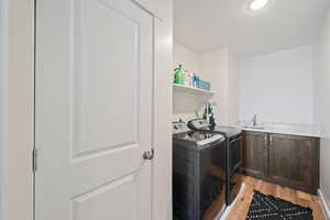 Washroom featuring light wood finished floors and washing machine and dryer