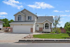 View of front of property with concrete driveway, brick siding, a garage, and central air condition unit