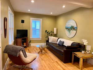 Living area featuring baseboards, light wood-style flooring, and recessed lighting