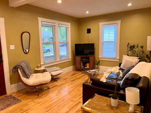 Living room featuring baseboards, a wealth of natural light, light wood finished floors, and recessed lighting