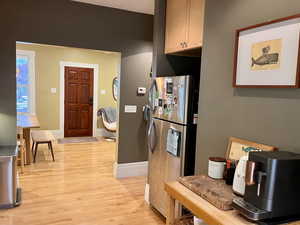 Kitchen with freestanding refrigerator, light wood-type flooring, and baseboards