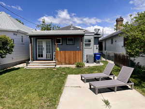 Rear view of house featuring french doors, a yard, fence, and central AC