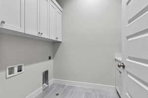 Laundry room with cabinet space, washer hookup, hookup for an electric dryer, and baseboards