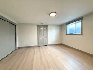 Empty room featuring light wood-type flooring, visible vents, and baseboards