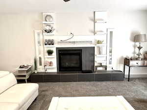 Carpeted living area with a tile fireplace