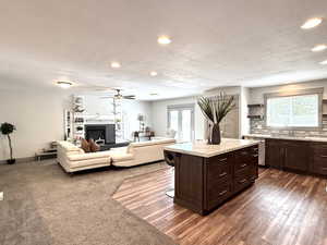 Kitchen with recessed lighting, a textured ceiling, stainless steel dishwasher, a sink, and light countertops