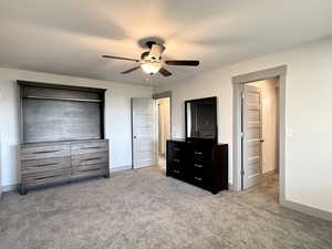 Carpeted bedroom featuring ceiling fan and baseboards