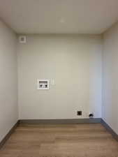 Laundry room featuring electric dryer hookup, laundry area, washer hookup, light wood-type flooring, and visible vents