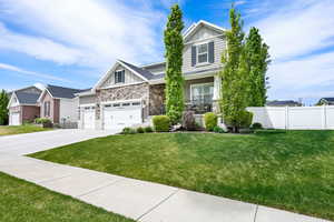Craftsman house featuring board and batten siding, stone siding, and driveway