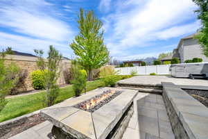 View of patio featuring an outdoor fire pit, a fenced backyard, and a hot tub