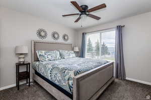 Carpeted bedroom with baseboards and ceiling fan