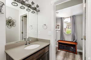 Bathroom with wood finished floors, vanity, and baseboards