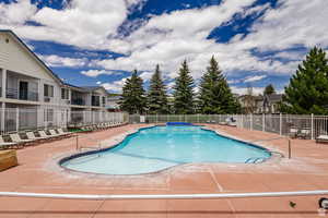 Community pool with fence and a patio