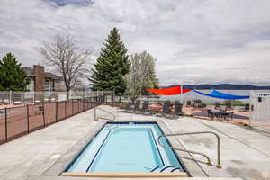 Community pool featuring fence and a patio area