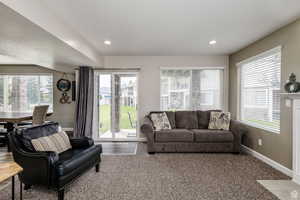 Carpeted living area with baseboards and recessed lighting