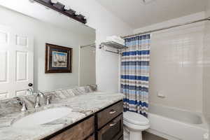 Full bath featuring toilet, vanity, shower / bath combo, and tile patterned flooring